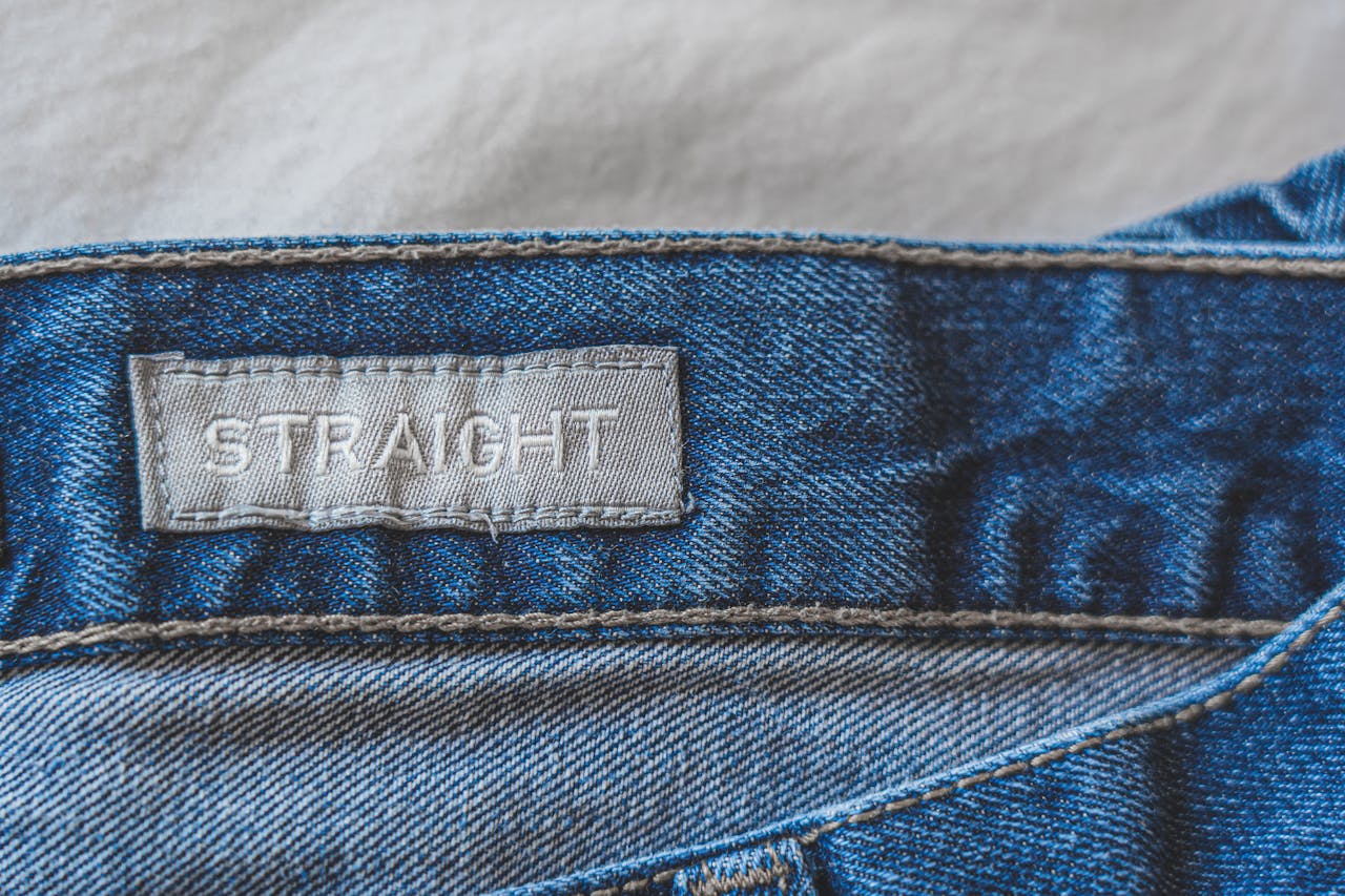 Detailed photo of blue denim jeans featuring a straight fit label.
